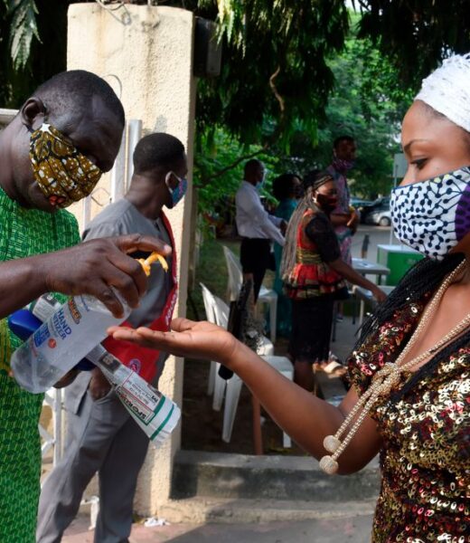 A woman wearing face mask sanitise her hands outside the St. Agnes Catholic Church, Maryland in Lagos following the reopening of Churches and lifting of restrictions on religious gatherings by the government as precaution to check the spread of COVID-19 Coronavirus at the Holy Cross Cathedral, on August 9, 2020. - Nigerian government has lifted the ban on religious gathering across the country as measure to check the spread of the novel COVID-19 pandemic, but with conditions that worshippers adhere strictly to precautionary measures to curtail the spread of the virus. (Photo by PIUS UTOMI EKPEI / AFP) (Photo by PIUS UTOMI EKPEI/AFP via Getty Images)